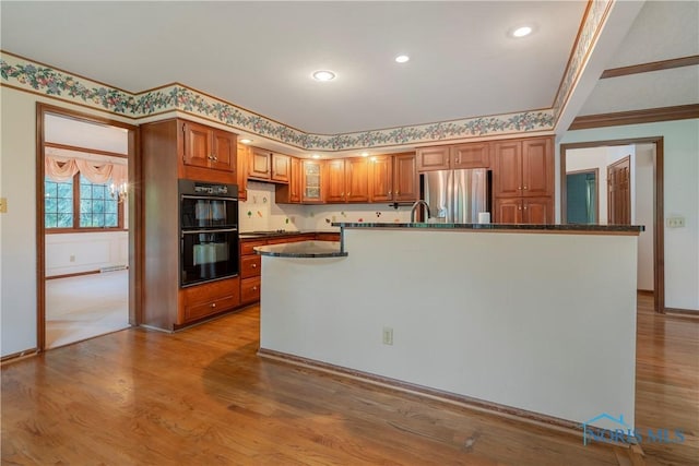 5301 River Oaks Ct, Sylvania, OH 43560 - kitchen with freestanding refrigerator, brown cabinetry, wood finished floors, cooktop, and recessed lighting