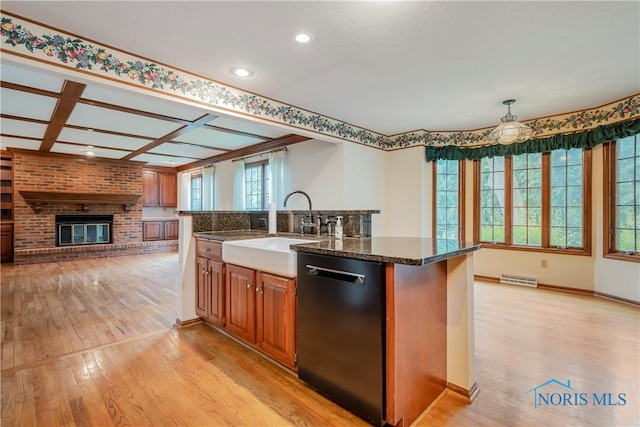 5301 River Oaks Ct, Sylvania, OH 43560 - kitchen featuring black dishwasher, a brick fireplace, light wood-style flooring, open floor plan, and brown cabinetry