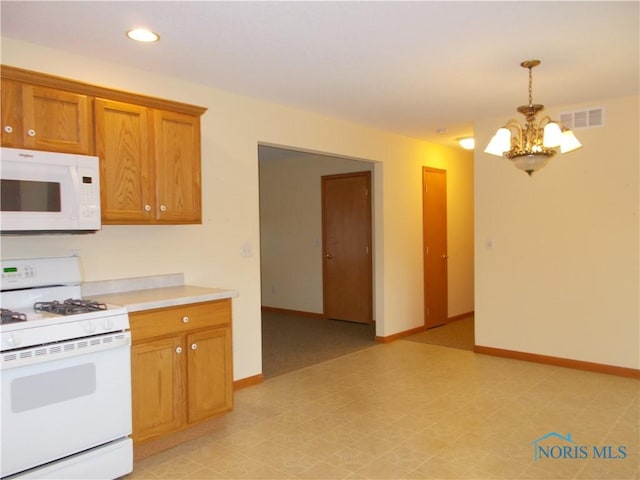 2971 County Road 12, Wauseon, OH 43567 - kitchen with white appliances, a chandelier, brown cabinets, light countertops, and hanging light fixtures