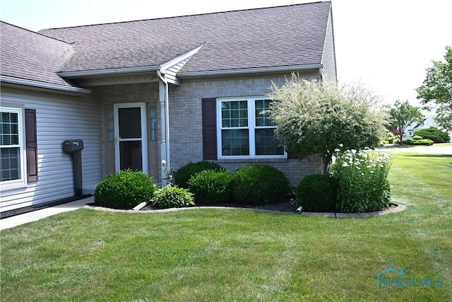 4547 Harbour Creek Ct, Maumee, OH 43537 - entrance to property with a shingled roof, a yard, and brick siding