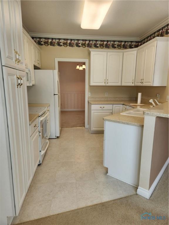 4547 Harbour Creek Ct, Maumee, OH 43537 - kitchen with white appliances, white cabinets, a peninsula, crown molding, and light countertops