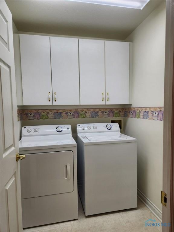 4547 Harbour Creek Ct, Maumee, OH 43537 - washroom with cabinet space, separate washer and dryer, and light tile patterned flooring