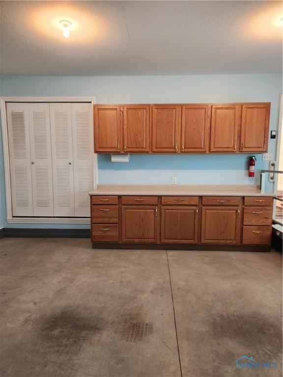 4547 Harbour Creek Ct, Maumee, OH 43537 - kitchen with brown cabinetry, light countertops, and concrete flooring