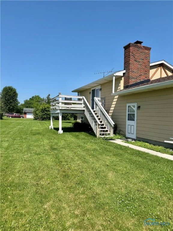 410 E Bartlow St, Deshler, OH 43516 - back of house featuring a wooden deck, a chimney, a lawn, and stairs