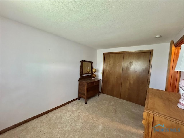 410 E Bartlow St, Deshler, OH 43516 - bedroom with light carpet, a closet, and a textured ceiling