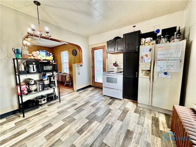 620 Division St, Defiance, OH 43512 - kitchen with white appliances, a chandelier, light wood-style floors, and pendant lighting