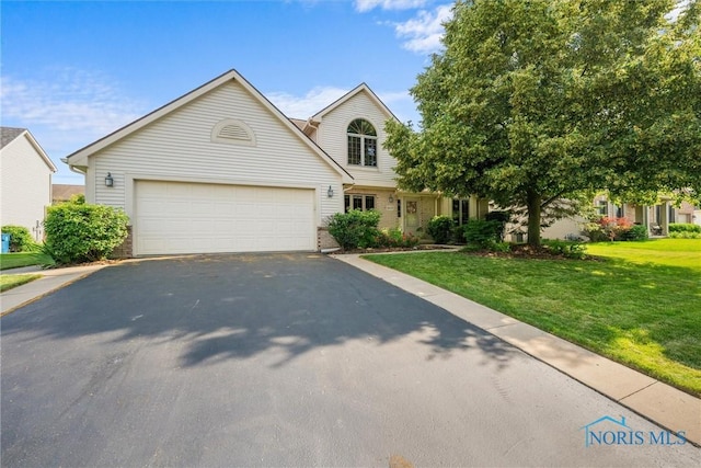 14691 Ramblehurst Dr, Perrysburg, OH 43551 - view of front of home featuring asphalt driveway, a front yard, a garage, and brick siding