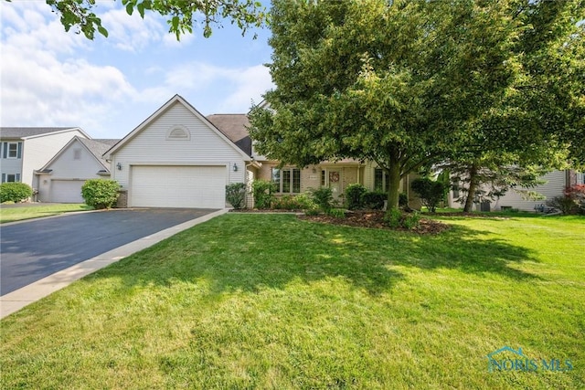 14691 Ramblehurst Dr, Perrysburg, OH 43551 - view of front facade with asphalt driveway, a garage, and a front lawn