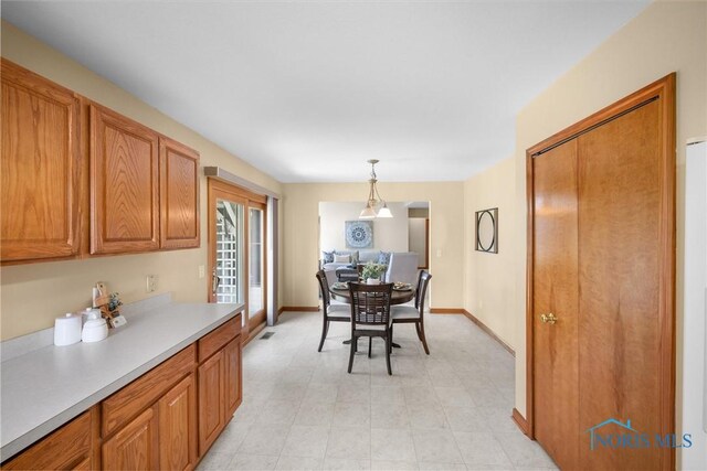 14691 Ramblehurst Dr, Perrysburg, OH 43551 - kitchen with light countertops, brown cabinets, hanging light fixtures, and light floors