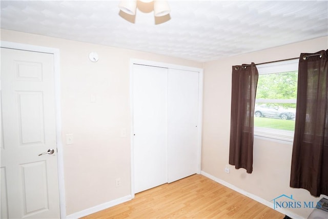 317 E Rosewood Ave, Defiance, OH 43512 - unfurnished bedroom featuring light wood finished floors, a closet, and a ceiling fan