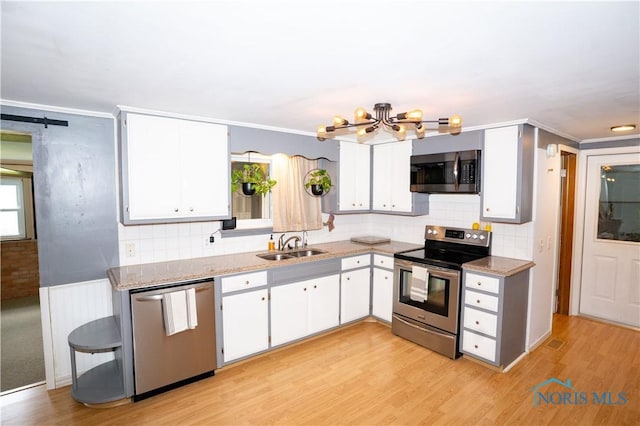 317 E Rosewood Ave, Defiance, OH 43512 - kitchen with appliances with stainless steel finishes, a chandelier, white cabinets, decorative backsplash, and crown molding