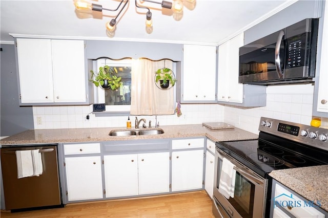 317 E Rosewood Ave, Defiance, OH 43512 - kitchen with appliances with stainless steel finishes, tasteful backsplash, white cabinetry, light wood-style floors, and light stone counters