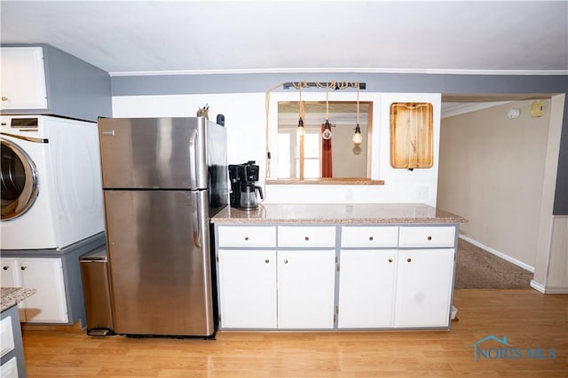 317 E Rosewood Ave, Defiance, OH 43512 - kitchen with freestanding refrigerator, white cabinetry, light wood-style flooring, light stone countertops, and crown molding