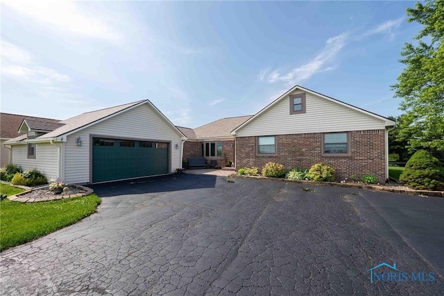 10549 Cygnet Rd, Cygnet, OH 43413 - single story home featuring an attached garage, asphalt driveway, and brick siding