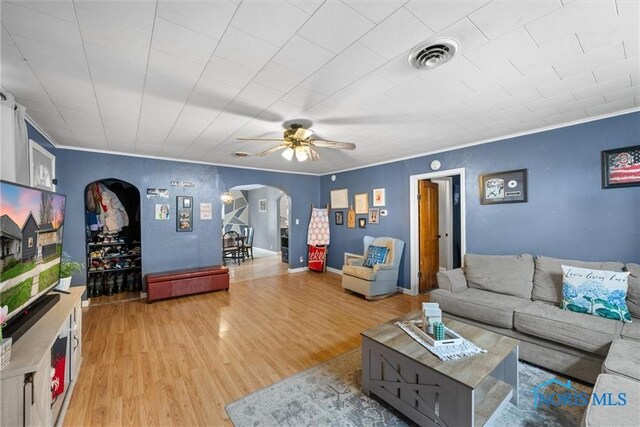 411 Seneca St, Defiance, OH 43512 - living area with arched walkways, a ceiling fan, wood finished floors, and crown molding