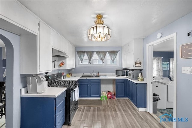 411 Seneca St, Defiance, OH 43512 - kitchen with black gas range, blue cabinetry, independent washer and dryer, light wood-style flooring, and arched walkways