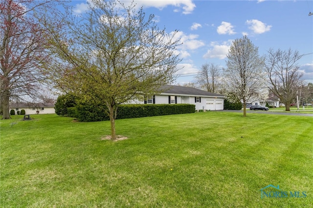 807 S Jefferson St, Pandora, OH 45877 - view of green lawn with a garage and driveway