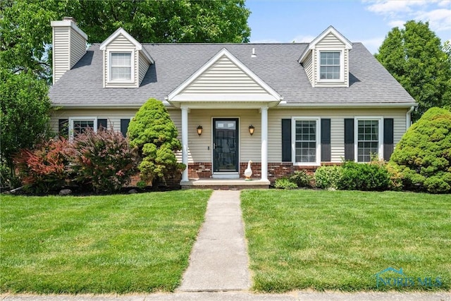 3005 Springwood St, Oregon, OH 43616 - new england style home featuring a chimney, a front yard, covered porch, and brick siding