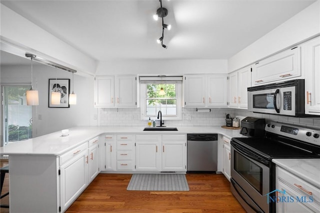 3005 Springwood St, Oregon, OH 43616 - kitchen featuring appliances with stainless steel finishes, a peninsula, light countertops, and backsplash