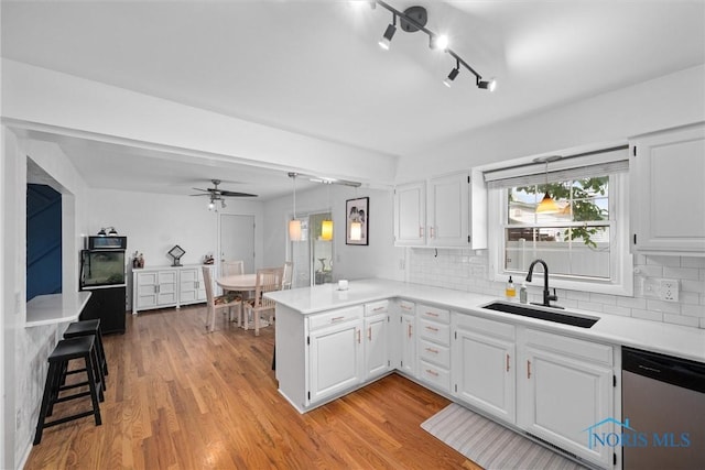 3005 Springwood St, Oregon, OH 43616 - kitchen featuring dishwasher, a peninsula, white cabinets, and light countertops