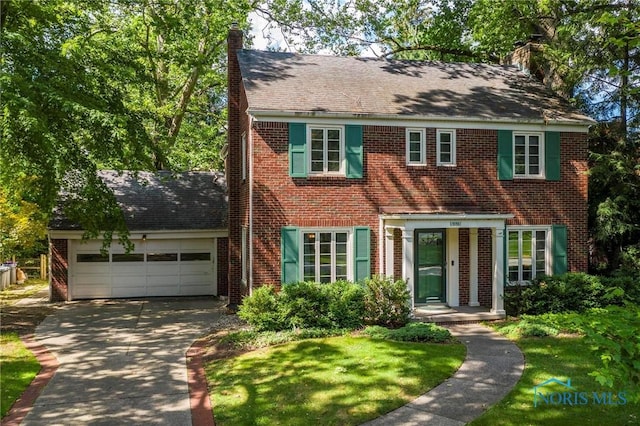 4146 Northmoor Rd, Ottawa Hills, OH 43606 - view of front facade with brick siding, a chimney, a garage, concrete driveway, and a front lawn