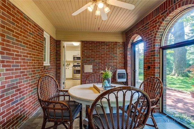 4146 Northmoor Rd, Ottawa Hills, OH 43606 - sunroom / solarium with brick wall, wooden ceiling, ceiling fan, stone finish flooring, and heating unit