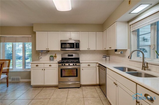 4146 Northmoor Rd, Ottawa Hills, OH 43606 - kitchen with stainless steel appliances, backsplash, light tile patterned floors, and light countertops