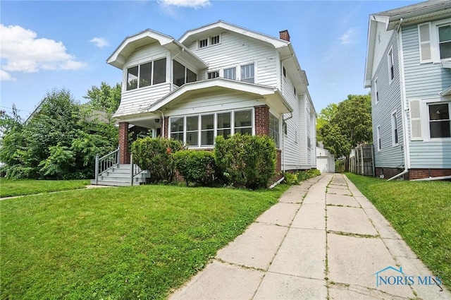 1452 Rollins Rd, Toledo, OH 43612 - view of front facade with a front yard, brick siding, a chimney, and a garage