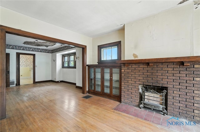 1452 Rollins Rd, Toledo, OH 43612 - unfurnished living room featuring light wood-type flooring and a brick fireplace