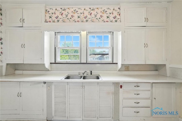 1452 Rollins Rd, Toledo, OH 43612 - kitchen with white cabinets, light countertops, and wallpapered walls