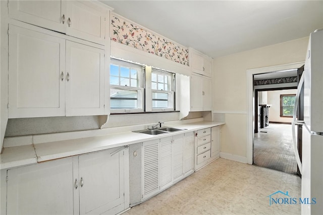 1452 Rollins Rd, Toledo, OH 43612 - kitchen with freestanding refrigerator, light countertops, light flooring, and white cabinets