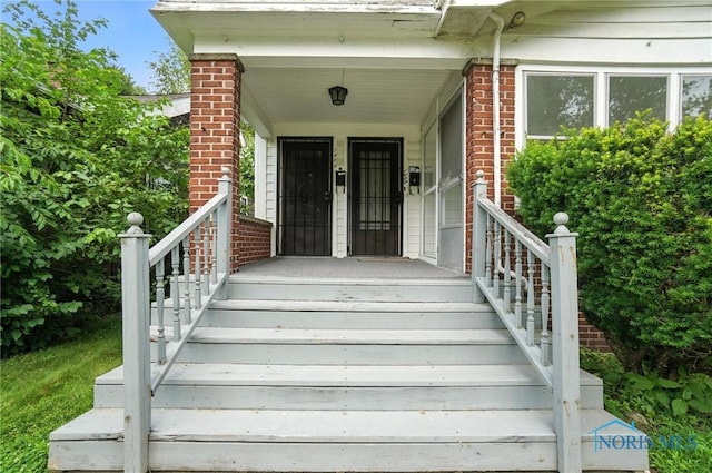 1452 Rollins Rd, Toledo, OH 43612 - view of exterior entry featuring brick siding and a porch