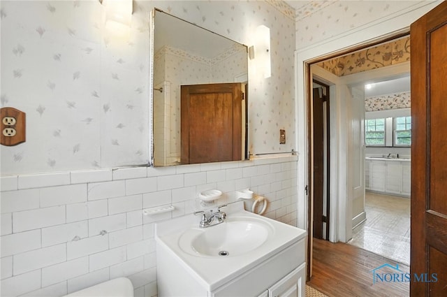 1452 Rollins Rd, Toledo, OH 43612 - bathroom featuring wallpapered walls, vanity, a wainscoted wall, and wood finished floors