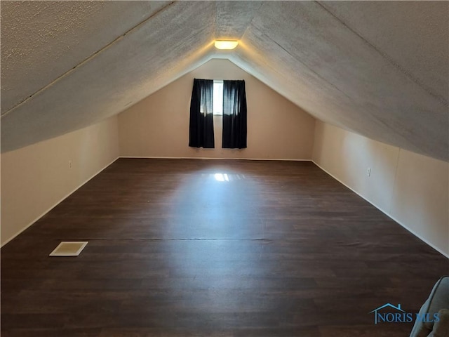 3906 Watson Ave, Toledo, OH 43612 - bonus room featuring vaulted ceiling, dark wood-style flooring, and a textured ceiling