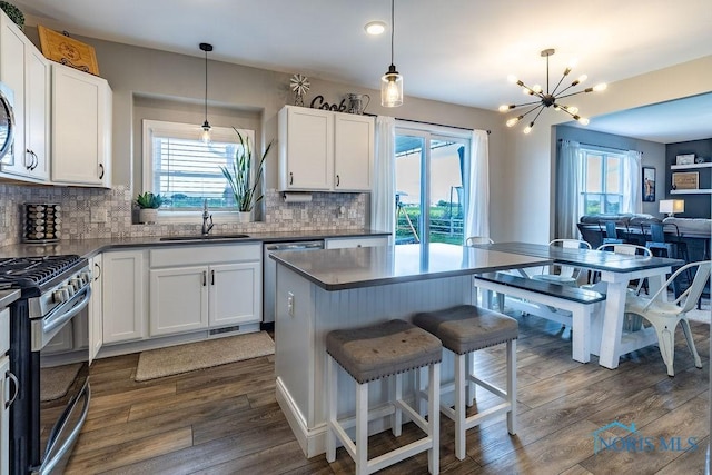 5539 Harris Hawk Ln, Sylvania, OH 43560 - kitchen featuring stainless steel appliances, a chandelier, open floor plan, decorative backsplash, and white cabinetry