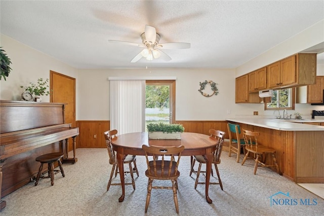 17918 Dunbridge Rd, Bowling Green, OH 43402 - dining room with a wainscoted wall, ceiling fan, wooden walls, a textured ceiling, and light carpet