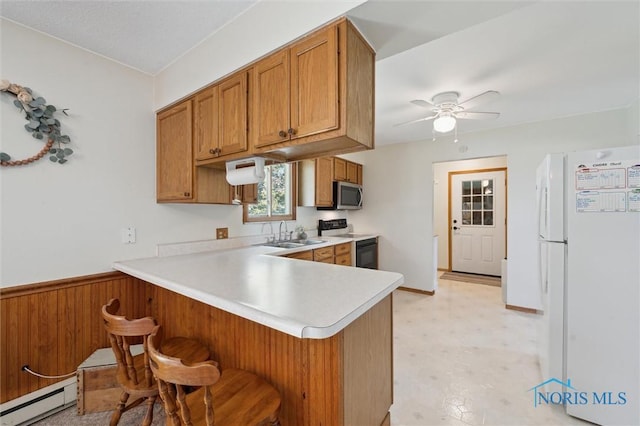 17918 Dunbridge Rd, Bowling Green, OH 43402 - kitchen featuring freestanding refrigerator, stainless steel microwave, a baseboard radiator, electric range oven, and brown cabinets