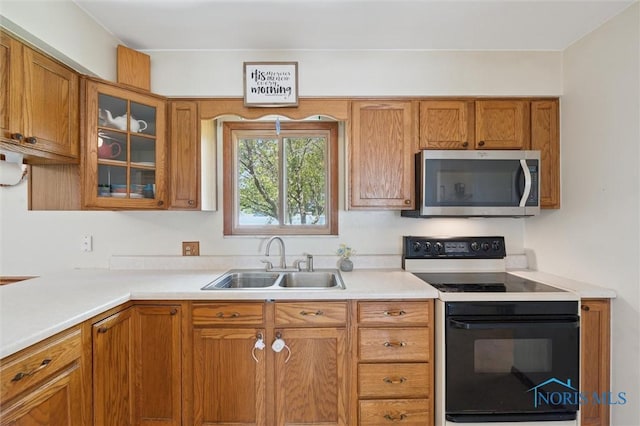 17918 Dunbridge Rd, Bowling Green, OH 43402 - kitchen featuring stainless steel microwave, range with electric cooktop, brown cabinetry, light countertops, and glass insert cabinets