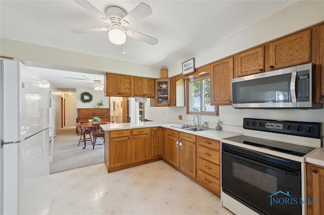 17918 Dunbridge Rd, Bowling Green, OH 43402 - kitchen with electric range oven, stainless steel microwave, freestanding refrigerator, brown cabinetry, and a peninsula