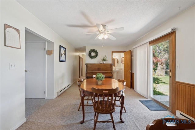 17918 Dunbridge Rd, Bowling Green, OH 43402 - carpeted dining space with baseboard heating, a ceiling fan, a textured ceiling, and a wainscoted wall