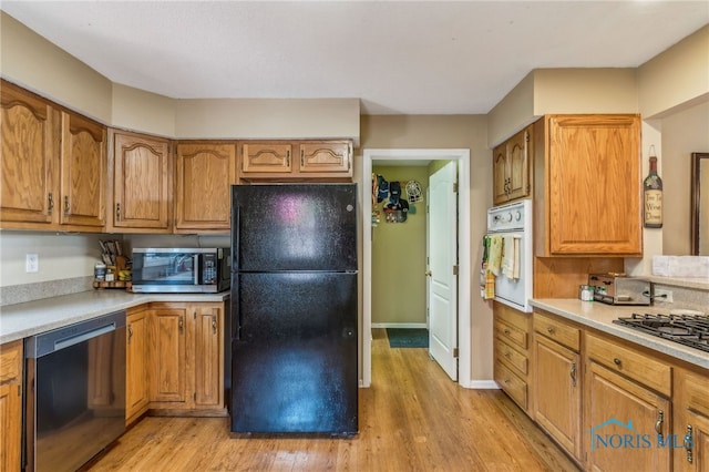 625 W Lake Ct Unit U5, Findlay, OH 45840 - kitchen featuring appliances with stainless steel finishes, light wood-style flooring, brown cabinets, and light countertops