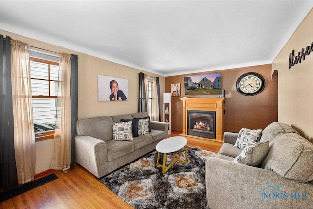 721 Colima Dr, Toledo, OH 43609 - living area with wood finished floors, a glass covered fireplace, and arched walkways