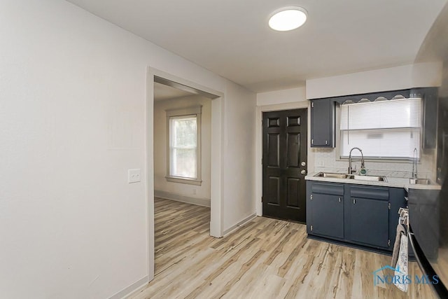 3947 Burnham Ave, Toledo, OH 43612 - kitchen featuring light countertops, light wood-type flooring, decorative backsplash, and plenty of natural light