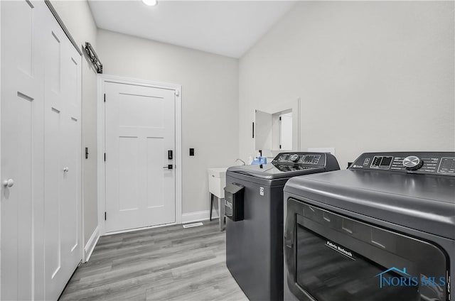 9414 Sheffield Rd, Perrysburg, OH 43551 - laundry room with washing machine and clothes dryer and light wood-type flooring