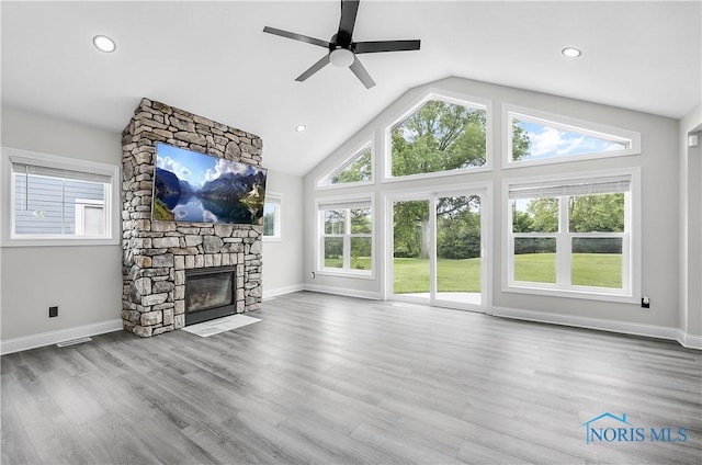 9414 Sheffield Rd, Perrysburg, OH 43551 - unfurnished living room with ceiling fan, a stone fireplace, lofted ceiling, wood finished floors, and recessed lighting