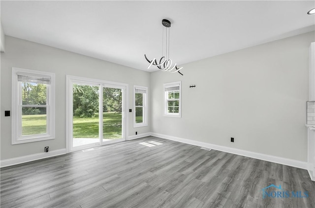 9414 Sheffield Rd, Perrysburg, OH 43551 - unfurnished dining area with wood finished floors and a chandelier