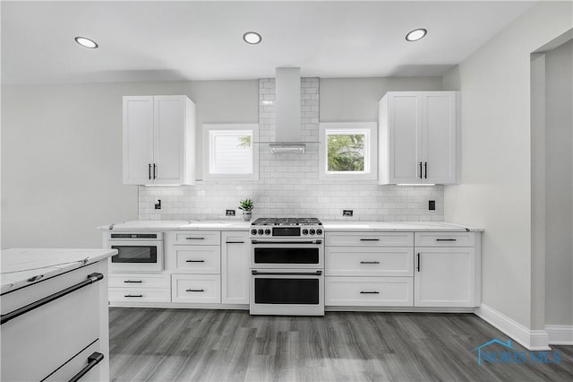 9414 Sheffield Rd, Perrysburg, OH 43551 - kitchen featuring range with two ovens, wall chimney exhaust hood, wood finished floors, white cabinets, and recessed lighting