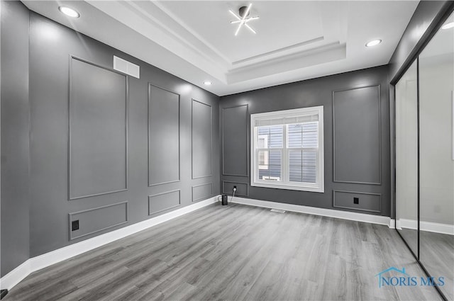 9414 Sheffield Rd, Perrysburg, OH 43551 - spare room with wood finished floors, a decorative wall, a raised ceiling, and recessed lighting