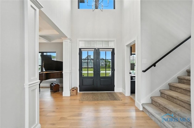 4214 Thornbury Ct, Perrysburg, OH 43551 - entrance foyer with decorative columns, stairs, a chandelier, a towering ceiling, and light wood finished floors