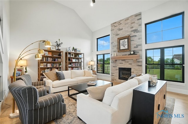 4214 Thornbury Ct, Perrysburg, OH 43551 - living room with high vaulted ceiling, a fireplace, light wood finished floors, and healthy amount of natural light